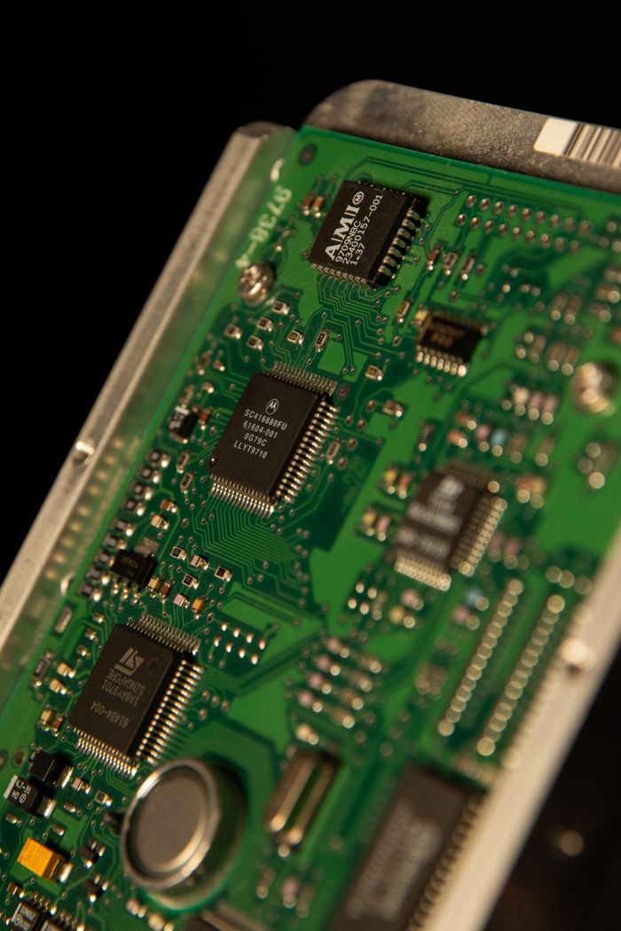 Detailed view of a green electronic circuit board showcasing microchips and components.
