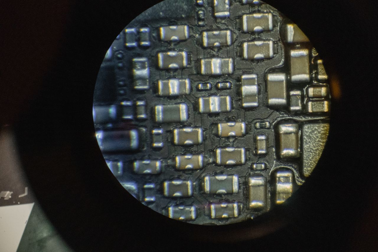 Services Detailed image of microchip components viewed through a microscope lens.